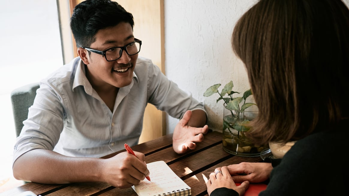 business-coaching-two-people-talk-at-a-desk