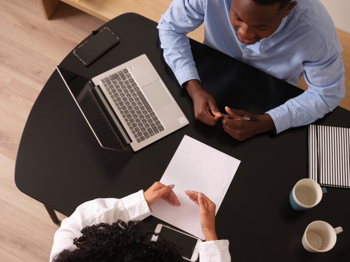 business-coaching-two-people-talk-at-a-table-aerial-view- business-coaching