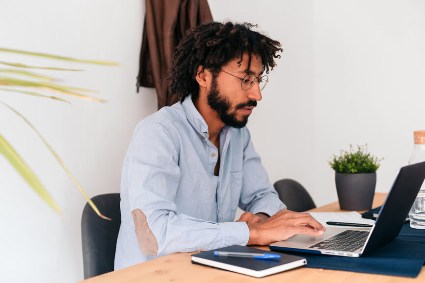 man-in-front-of-laptop-using-mobile-phone-employee-retention